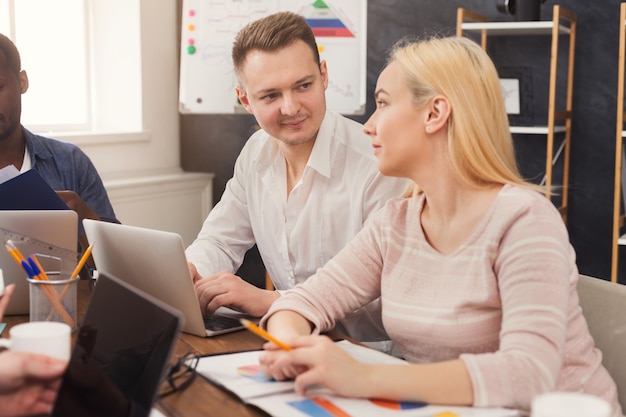 Empresários concentrados trabalhando no escritório. Equipe jovem e ocupada estudando um novo projeto ou relatório financeiro, copie o espaço