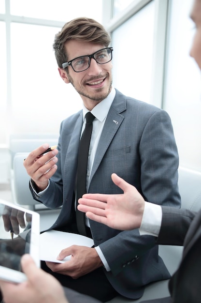 Empresarios contemporáneos que trabajan conectados con dispositivos tecnológicos como tabletas y computadoras portátiles hablando juntos financian el concepto de tecnología empresarial