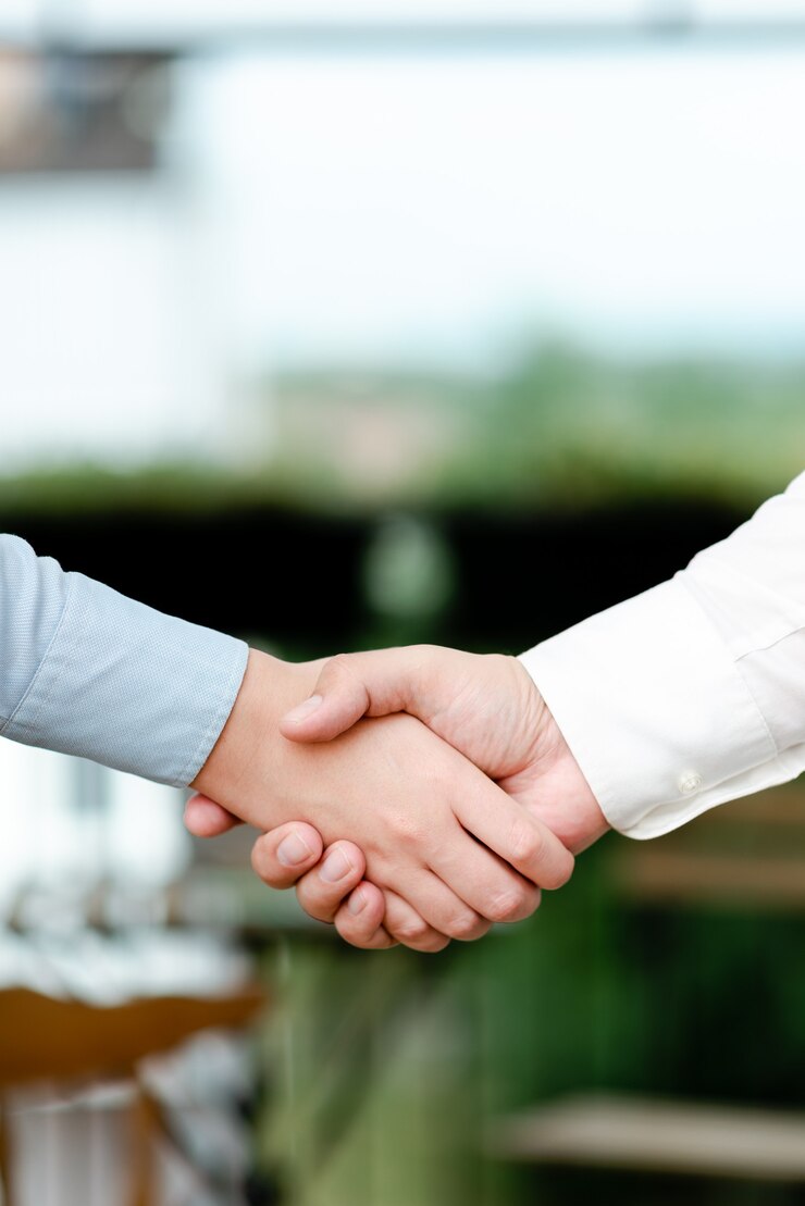 Foto empresarios corporativos apretón de manos en el interior.dos personas bien vestidas profesionalmente gesticulando unión.colega de trabajo socios firman acuerdo en acuerdo de contrato