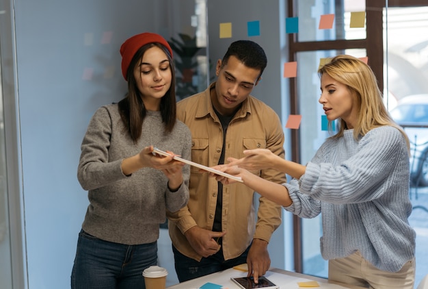 Foto empresarios creativos que trabajan juntos, discuten el inicio, colaboran usando scrum, notas adhesivas