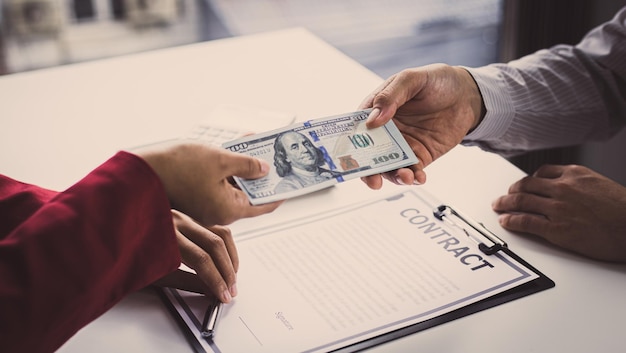 Foto los empresarios dan dólares para sobornar a los empleados en la firma de contratos para comprar tierras e bienes raíces ilegales