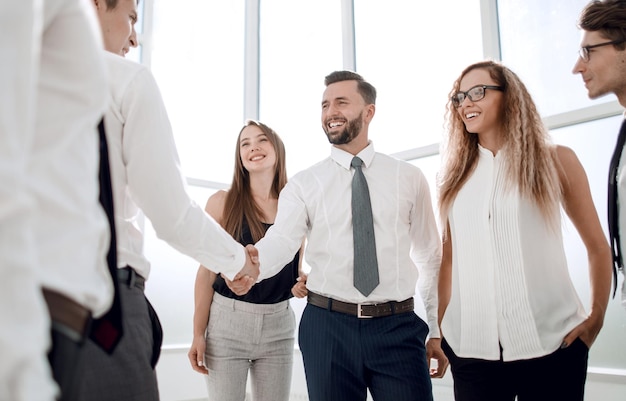 Los empresarios se dan la mano de pie en las reuniones y asociaciones de la oficina