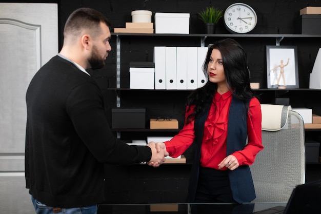 Empresarios se dan la mano en una reunión en una elegante oficina