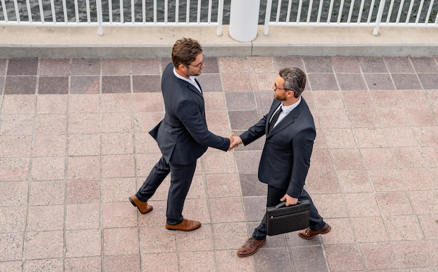 Foto empresários de trabalho em equipe bem-sucedidos apertando as mãos empresários de terno apertando as mãos ao ar livre handsha