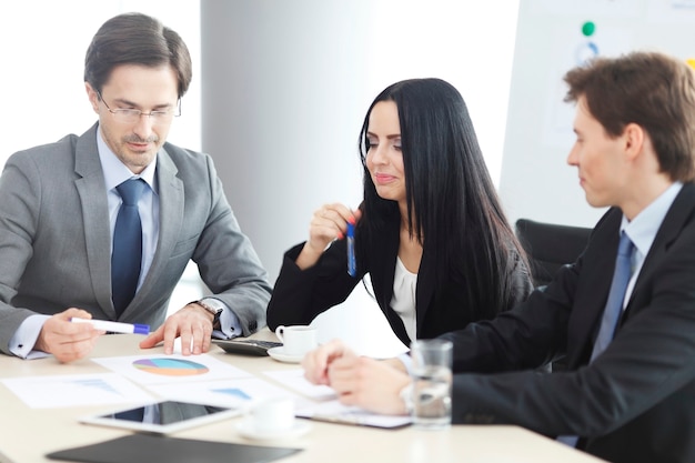 Empresários discutindo relatórios financeiros durante uma reunião