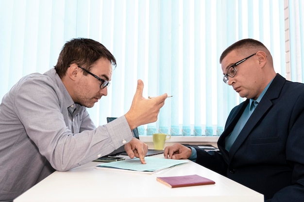 Empresários e advogados discutindo contrato sentado à mesa chefe de homem está assinando papéis Comunicação empresarial no escritório Contratando um funcionário para trabalhar Persuasão para assinar um contrato