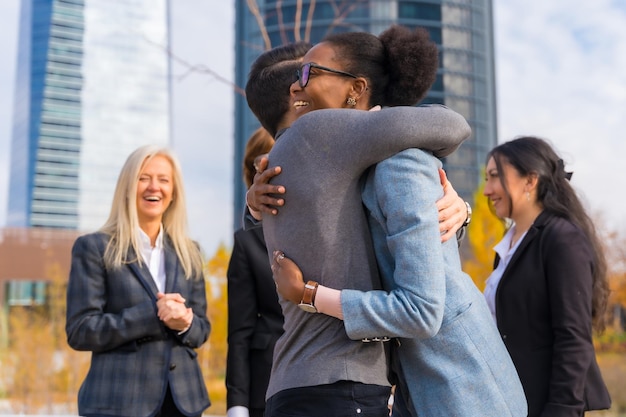 Foto empresários e empresárias multiétnicas de meia-idade se abraçando entre colegas