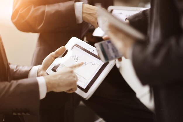 Empresários em reunião apresentando gráficos no tablet smartphone