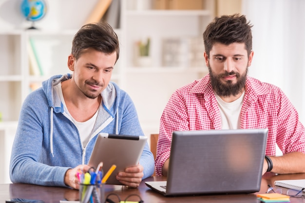 Empresarios en estilo casual usando computadoras en la oficina