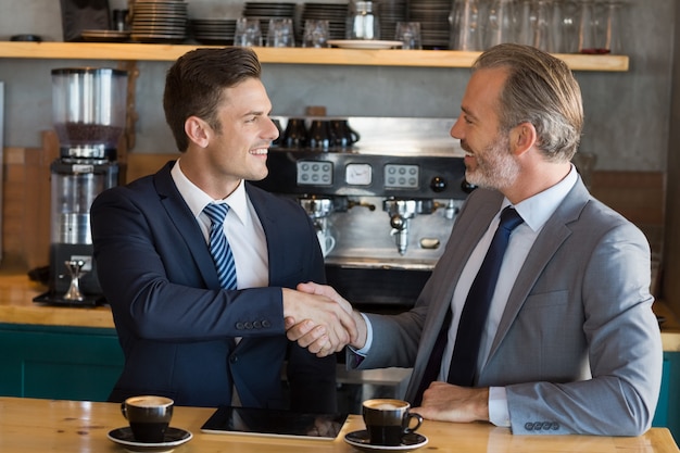 Empresarios estrechándose la mano en el café