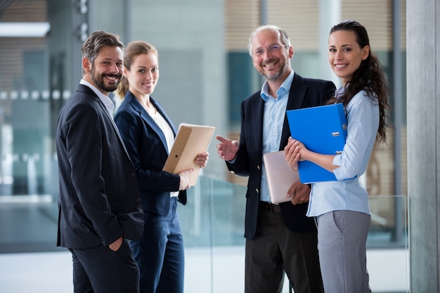 Empresarios felices de pie en el vestíbulo de la oficina