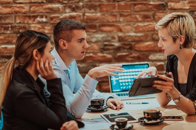 Empresarios felices sonriendo alegremente durante una reunión en una cafetería Grupo de profesionales empresariales exitosos que trabajan en equipo en un lugar de trabajo multicultural