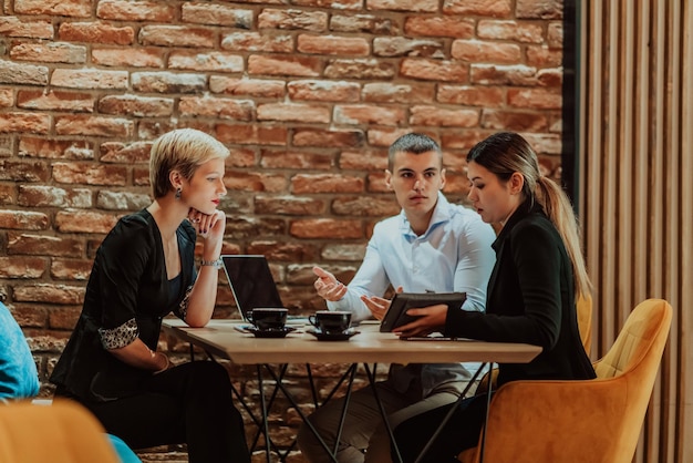 Empresarios felices sonriendo alegremente durante una reunión en una cafetería Grupo de profesionales empresariales exitosos que trabajan en equipo en un lugar de trabajo multicultural