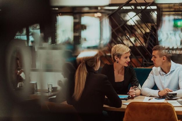 Empresarios felices sonriendo alegremente durante una reunión en una cafetería Grupo de profesionales empresariales exitosos que trabajan en equipo en un lugar de trabajo multicultural