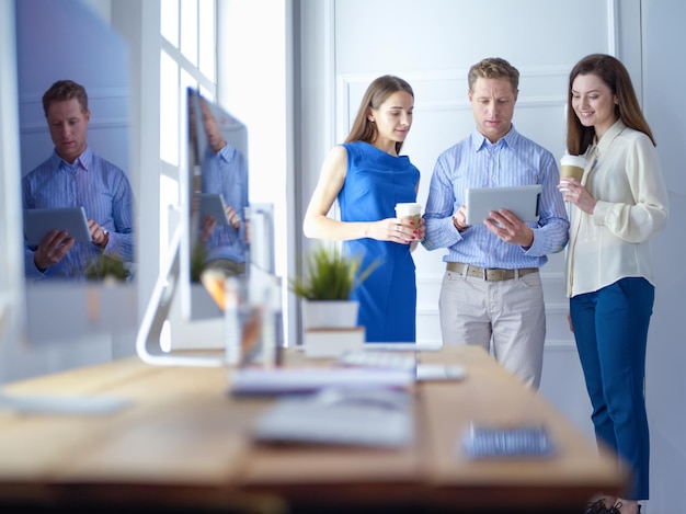 Empresarios felices usando tableta digital fuera del edificio de oficinas