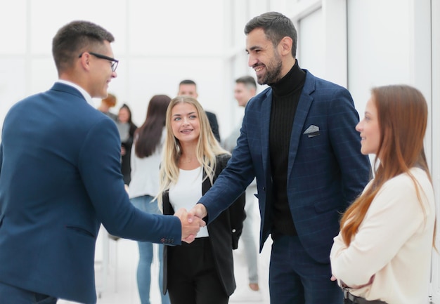 empresários felizes apertando as mãos uns dos outros. o conceito de cooperação