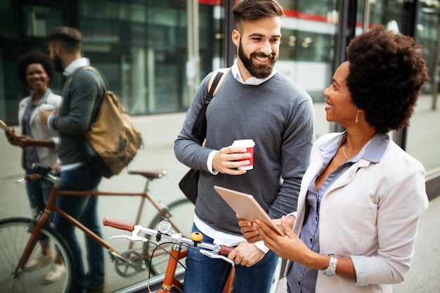 Empresários felizes discutindo e sorrindo enquanto caminham juntos ao ar livre