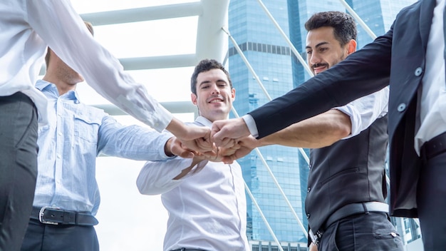 Foto empresarios golpeando los puños de pie contra el edificio