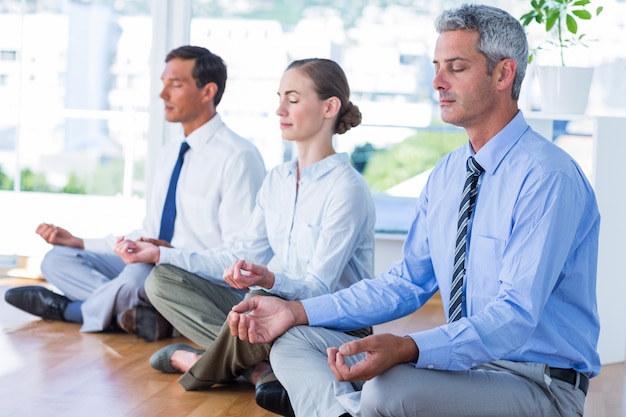 Foto empresarios haciendo yoga en el piso