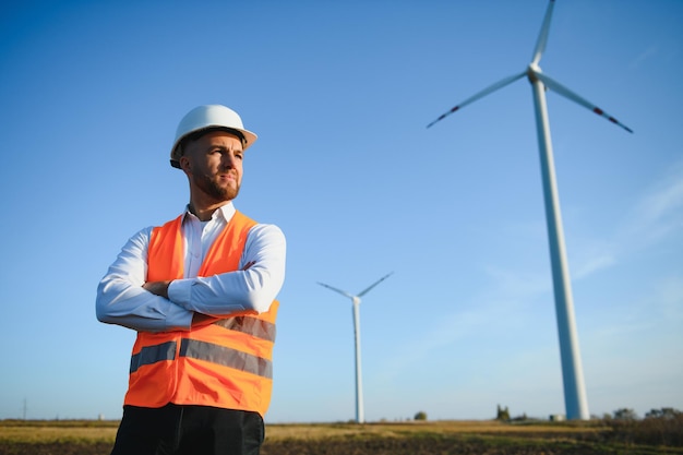 Los empresarios de ingeniería de pie hermosa sonrisa delante de la turbina mirando a otro lado