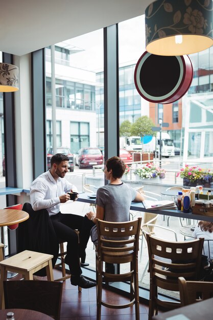 Empresarios interactuando mientras toman café