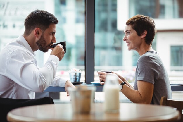 Empresarios interactuando mientras toman café