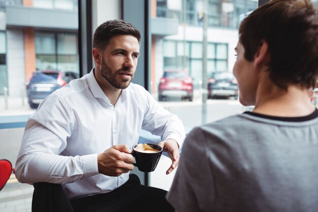 Empresários interagindo enquanto tomando café