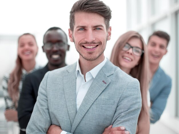 Empresarios internacionales de pie con los brazos cruzados sonriendo a la cámara