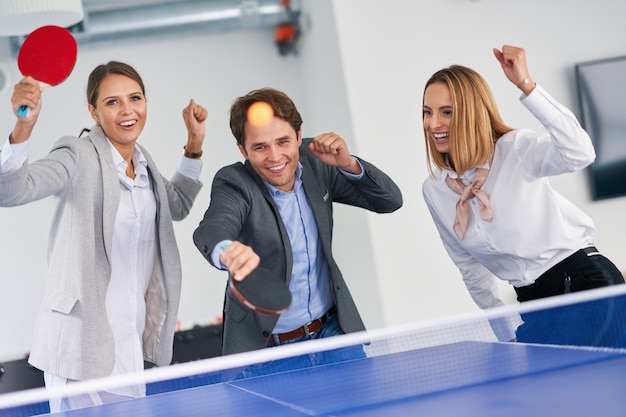 empresários jogando tênis de mesa em um escritório compartilhado