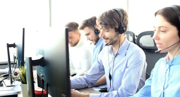 Foto empresários jovens positivos atraentes e colegas em um escritório de call center.