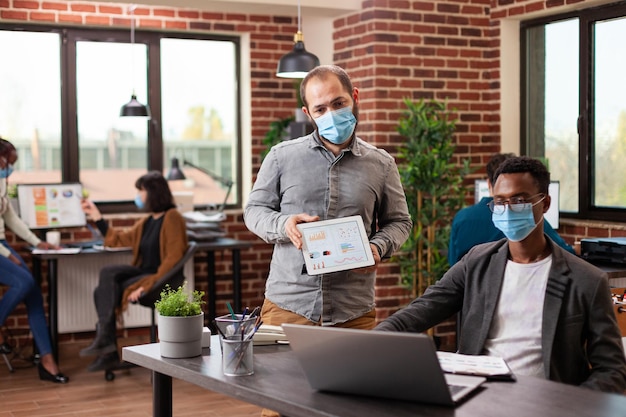 Foto empresarios con máscaras trabajando en la oficina