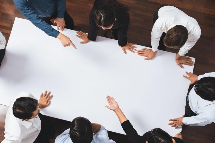 Foto empresarios en la mesa de reuniones señalando el espacio vacío prudente