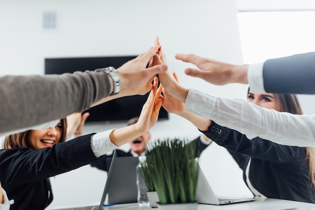 Empresarios mostrando trabajo en equipo y dando cinco después de firmar un acuerdo.