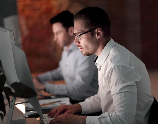 Empresarios en la oficina por la noche trabajando hasta tarde