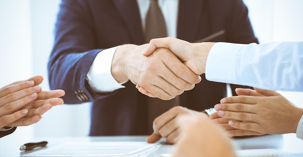 Empresários ou advogados apertando as mãos terminando uma reunião, close-up. Conceitos de negociação e aperto de mão.