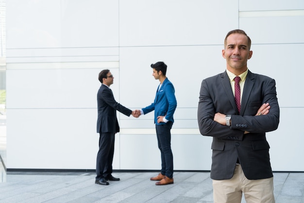 Empresários persas posando em frente a uma parede branca