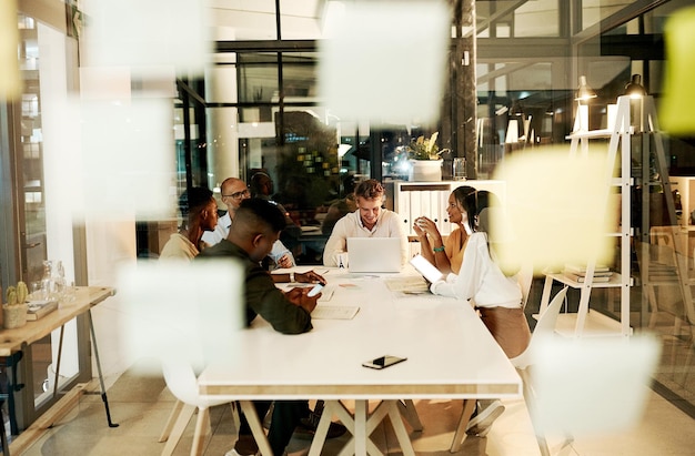 Empresarios profesionales creativos e informales reunidos con portátiles hablando y planificando un proyecto juntos en una oficina en el trabajo Diverso equipo de trabajadores felices y sonrientes discutiendo estrategia