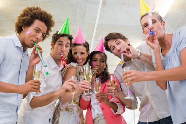 Empresários que comemoram no local de trabalho com copos de champanhe