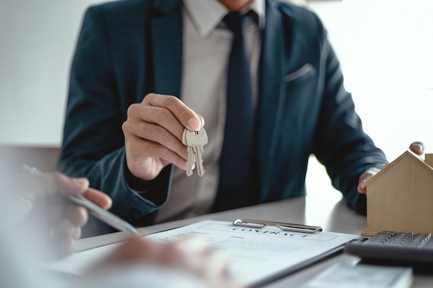 Foto empresarios que firman un contrato para hacer un trato con un agente inmobiliario concepto de consultor y concepto de seguro de hogar