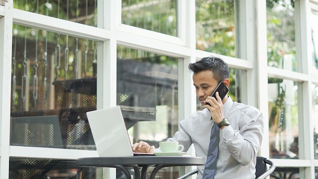 Empresarios que trabajan en computadoras con teléfono.