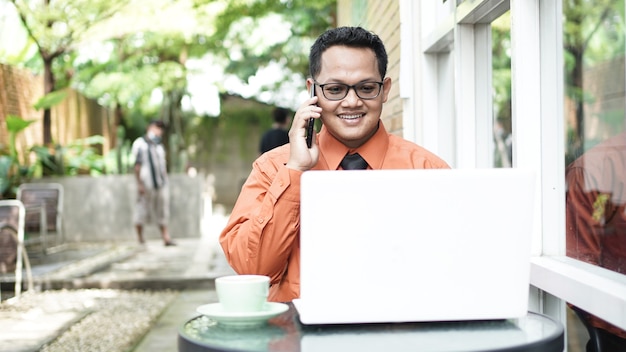 Empresarios que trabajan en computadoras con teléfono.