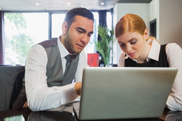 Empresários que trabalham juntos no laptop