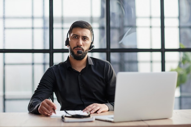 Los empresarios que usan auriculares que trabajan en la oficina amplían la vista