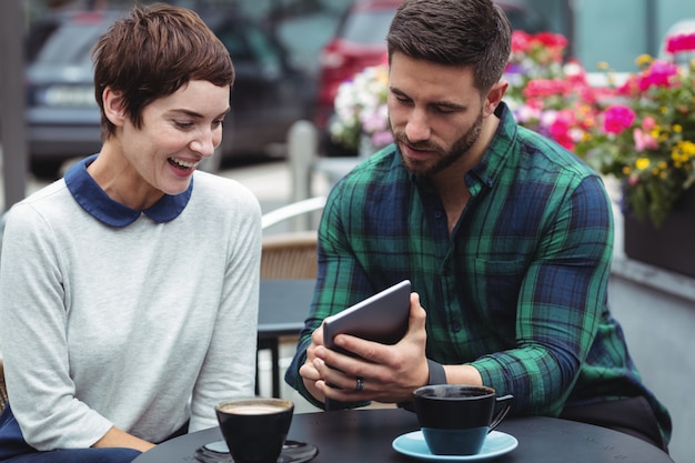 Empresarios que usan tableta digital mientras toman café