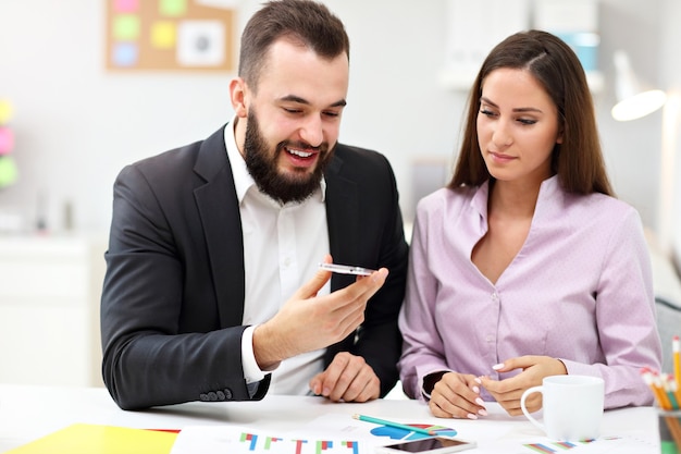 Foto los empresarios que utilizan sus teléfonos inteligentes en la oficina