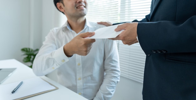 Foto empresários recebem salário ou bônus da administração ou da boss company dão recompensas para incentivar o trabalho empresário sorridente desfrutando de uma recompensa na mesa do escritório