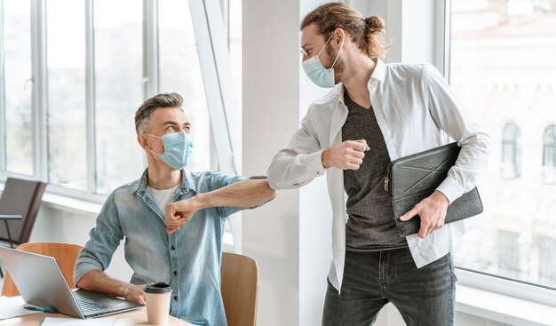 Foto empresários reunidos no escritório usando máscaras