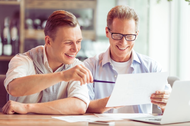 Empresarios en ropa casual están estudiando un documento.