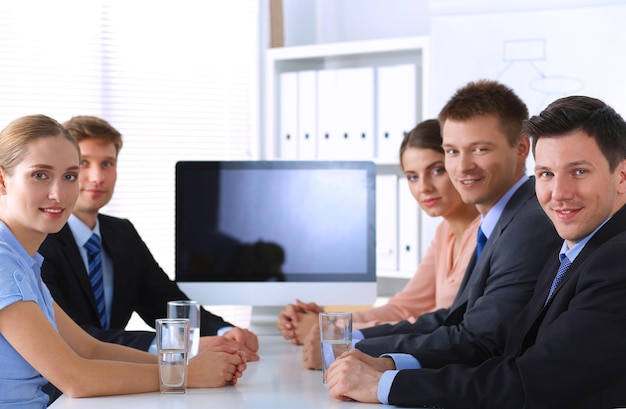 Foto empresarios sentados y discutiendo en la reunión de negocios en la oficina