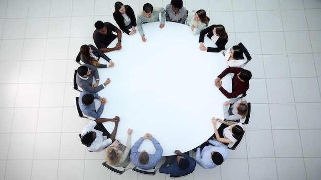 Empresários sentados em mesa redonda de conferência na reunião